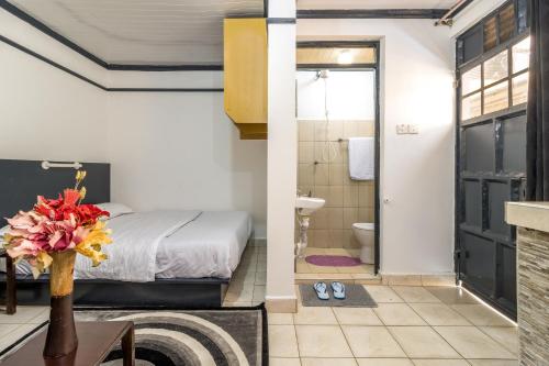 内罗毕AnD Suites的一间卧室设有一张床和一间浴室。