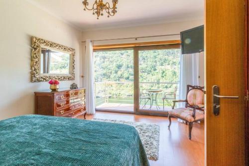辛方伊什Casa da Barragem Douro的一间卧室设有一张床、一个窗口和一把椅子