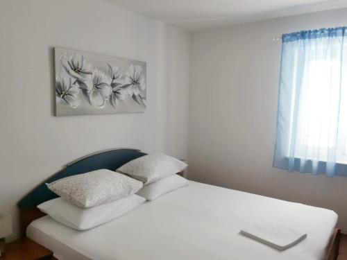 波维尔亚Apartment Tempera的卧室内的一张带两个枕头的白色床