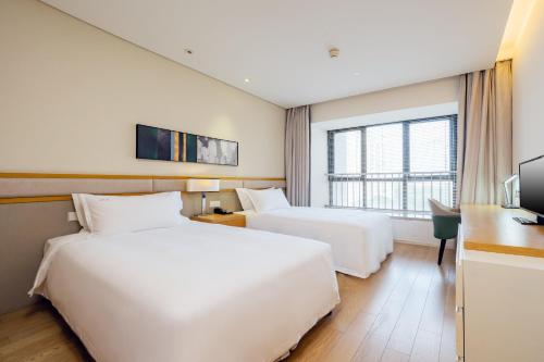 苏州苏州阳澄湖套房假日酒店的酒店客房配有两张床和一张书桌