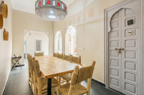 马拉喀什艾姆派尔摩洛哥传统庭院住宅的一间带木桌和椅子的用餐室