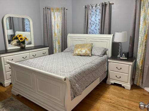 波士顿Boston Luxury 2 Bedroom Private Condo的一间卧室配有白色床、两个梳妆台和镜子