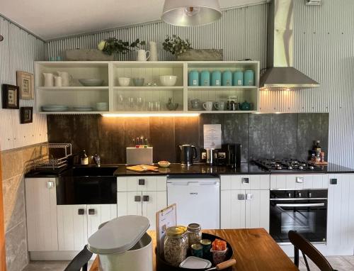 亚拉格林公寓 - 亚拉河谷的厨房配有白色橱柜和木桌