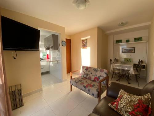 瓜拉派瑞Apartamento temporada com garagem, Wi-Fi, Netflix的带沙发的客厅和用餐室