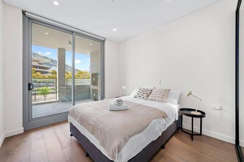 悉尼Commodious 2 Bedroom APT in OP的白色的卧室设有床和大窗户