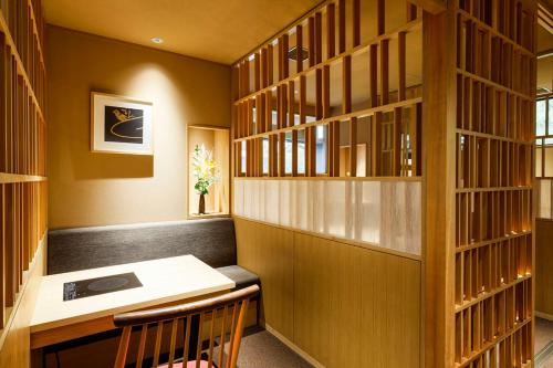 丰冈市汤乐城崎温泉花园旅馆的一个带木桌和木书架的图书馆