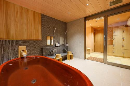 丰冈市汤乐城崎温泉花园旅馆的大型浴室设有浴缸和淋浴。