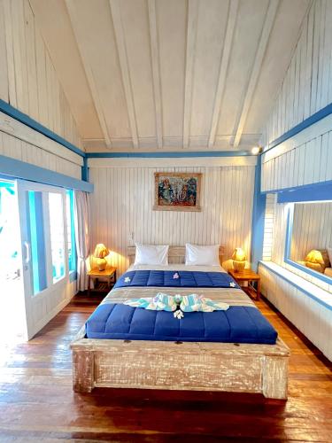 吉利阿尔Youpy Bungalows的一间卧室配有一张带蓝色床单的大床
