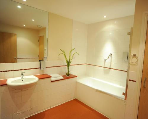 布里斯托普瑞米尔布里斯都酒店红崖套房公寓的一间带水槽、浴缸和卫生间的浴室