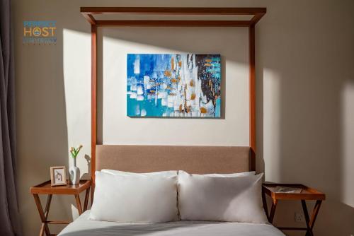 关丹Timurbay Beachfront by Perfect Host的一张位于酒店客房的床铺,上面有绘画作品