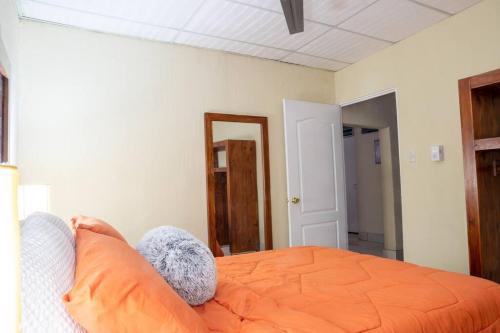 ChimaltenangoCOZY Fully equipped private apartment的一间卧室配有橙色的床和镜子