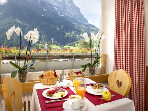 格林德尔瓦尔德格林德瓦布纳霍夫酒店的一张带早餐食品的桌子,享有山景