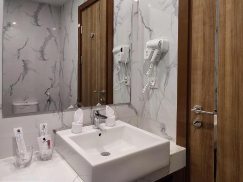 PatjinongongUNHAS HOTEL & CONVENTION的浴室设有白色水槽和镜子