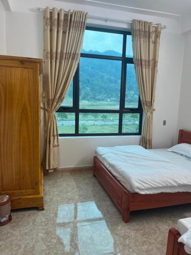 河江Minh Vân Hostel的一间卧室设有一张床和一个大窗户