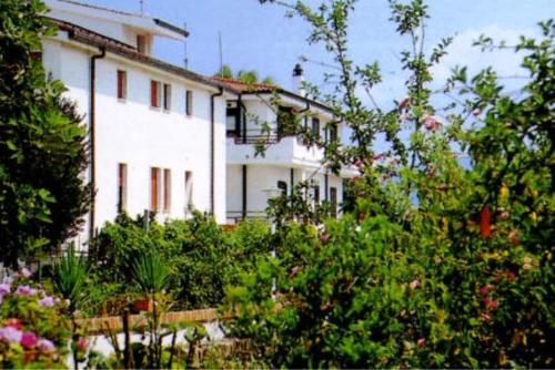 布里亚蒂科欧亚希住宅酒店的前面有树木的大白色房子