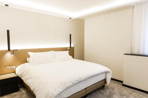 第戎Suite Montrachet 4 personnes vue cathédrale 1 Place de parking的一间卧室配有一张带白色床单的床和一扇窗户。
