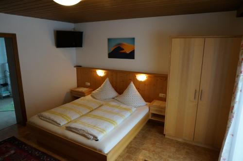 图克斯Erbhof Innertal的卧室配有一张床,墙上配有电视。