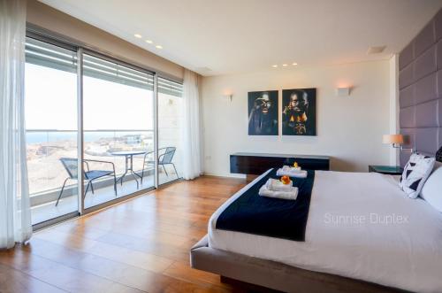 埃拉特YalaRent mountainside luxury Hotel apartments with Private Pool Eilat的一间带特大号床的卧室和一个阳台