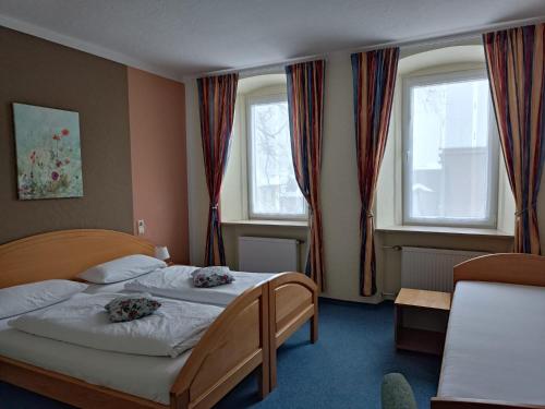 WeißenstadtGarni Hotel Post的一间卧室设有两张床和两个窗户。