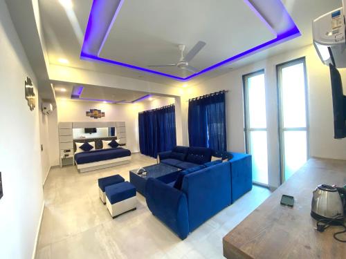诺伊达The Metro Stay By F9 Hotels-Near Sector 18 Metro Station Noida的一间带蓝色沙发的客厅和一间带窗户的房间