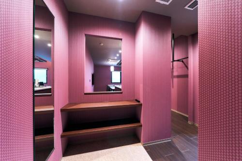 北九州Rakuten STAY Kokura Station Family Room的粉红色的浴室设有镜子和粉红色的墙壁