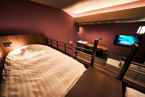 北九州Rakuten STAY Kokura Station Family Room的一间卧室配有一张大床和电视