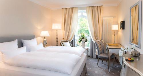 嫩尼希斯加罗斯伯格维克特雷迪斯酒店的酒店客房设有两张床、一张书桌和一个窗户。
