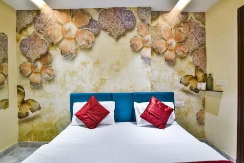 阿姆利则阿姆利则辛格国际酒店的一间卧室配有红色和白色枕头的床