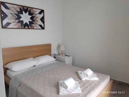 埃尔莫波利斯Smyrnis Apartments的一间卧室配有一张带两条白色毛巾的床