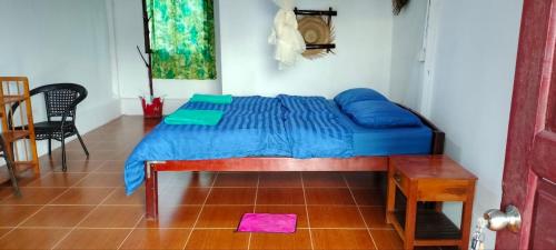 瓜隆岛Soksan Natura Beach的一间卧室配有一张带蓝色床单的床和一张桌子。