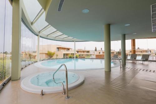 珀彻斯White Shell Beach Villas的大楼内带热水浴池的大型游泳池