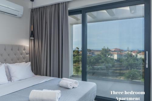 蒂锡利维Dionisos Luxury Suites的一间卧室设有一张床和一个大窗户