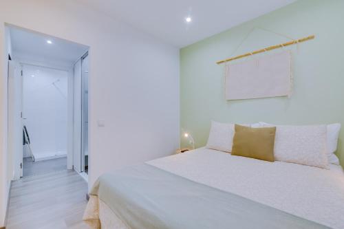 法鲁Faro: Casa Trevo com terraço BBQ的白色卧室配有一张白色大床和黄色枕头
