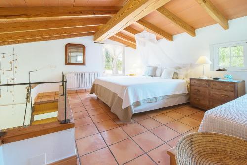 阿尔盖达Ca na Tinta的一间带一张大床的卧室,位于一个拥有木制天花板的房间