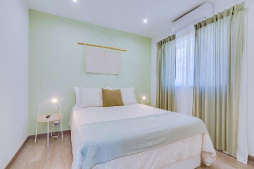 法鲁Faro: Casa Trevo com terraço BBQ的白色的卧室设有床和窗户