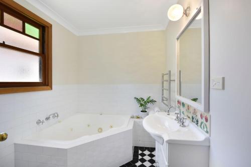卢拉Little Pomander的白色的浴室设有浴缸和水槽。