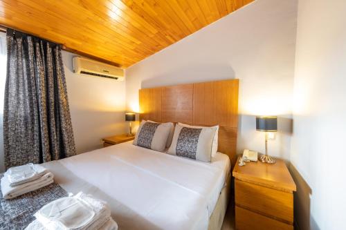 伊斯坦布尔King Suites Beşiktaş的卧室设有一张白色大床和木制天花板。