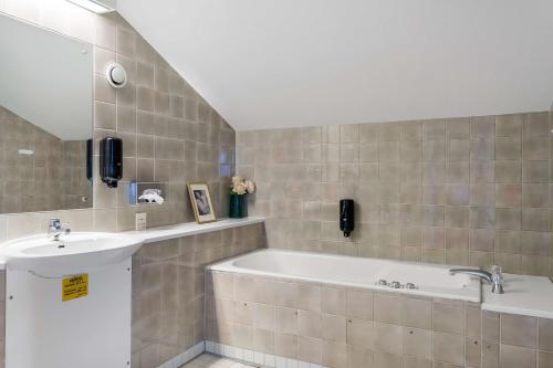 谢莱夫特奥玛米亚贝斯特韦斯特酒店的带浴缸和盥洗盆的浴室