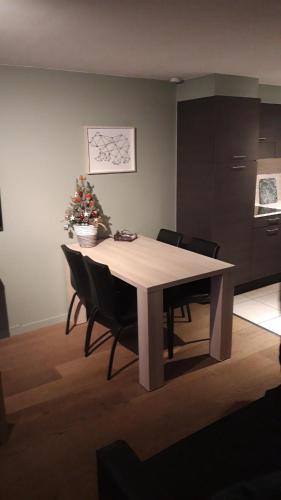 马尔梅迪Terrasses de Malmedy - Duplex 455的餐桌、椅子和圣诞树
