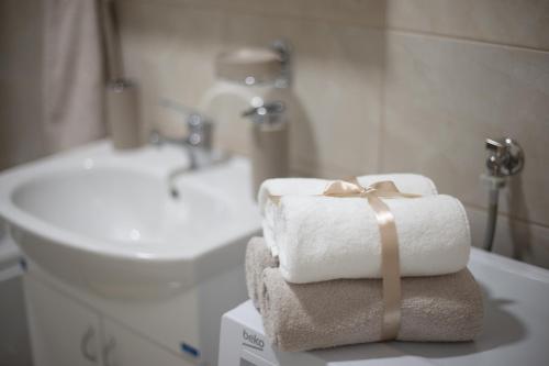 斯雷姆斯卡米特罗维察Apartman SUNSET的浴室桌子上摆放着一堆毛巾