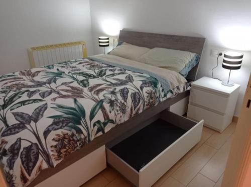 托里代巴拉Apartamento 3 habitaciones centro de Torredembarra的一间卧室配有一张带鲜花棉被的床