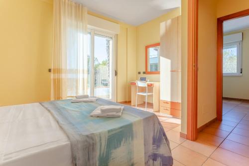 阿布鲁齐的罗塞托Residence Il Triangolo的一间设有床铺的卧室,位于带窗户的房间内