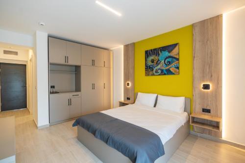 北马马亚-讷沃达里Onda Boutique Hotel的一间卧室设有一张大床和黄色的墙壁