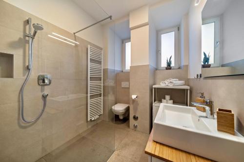 梅拉诺Central Suite Meran的一间带水槽、淋浴和卫生间的浴室