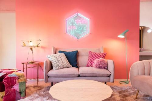 东京Moshi Moshi Rooms的带沙发和粉红色墙壁的客厅