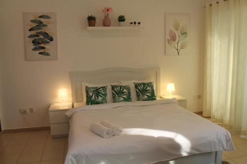 迪拜Bright, spacious and cozy studio apartment的卧室配有白色的床和2条毛巾