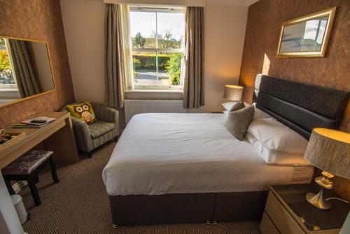 EdinbainOwlswood Apartments的酒店客房带一张大床和一把椅子