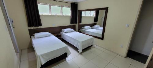 贝洛奥里藏特Sleep Suites的小房间设有两张床和镜子