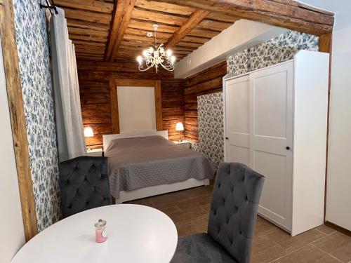 塔尔图Karlova Manor Apartments的配有一张床和一张桌子及椅子的房间
