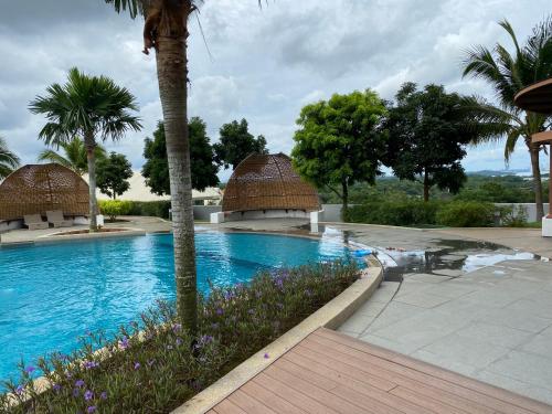 努沙再也Almas Suite的棕榈树和鲜花的度假游泳池